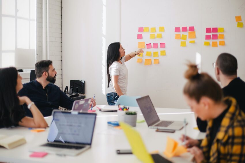 feature driven development - woman placing sticky notes on wall